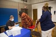 A resident is seated filling out paperwork with a nurse